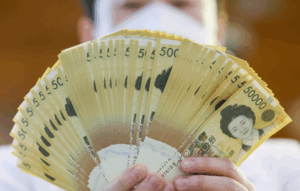 5만 원권 지폐 다발을 손에 든 모습, 예금자 보호 한도 확대 의미