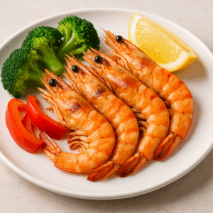 구운 대하 요리에 레몬 조각과 브로콜리, 피망이 곁들여져 신선하고 건강한 느낌을 주는 음식 이미지