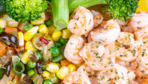 브로콜리와 옥수수, 피망 등 채소와 함께 플레이팅된 구운 새우 요리 클로즈업 이미지