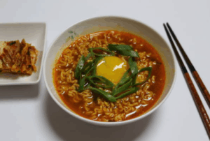 라면 먹을 때 부족한 영양소를 보완하는 달걀과 채소가 올려진 뜨거운 라면 한 그릇